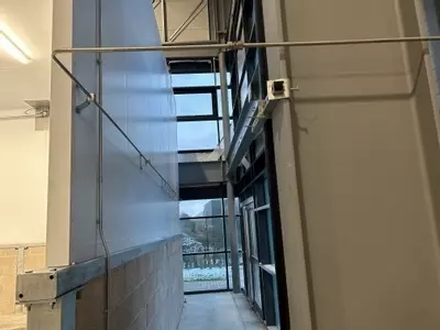 High-pressure stainless pipework routed along the rear wall to feed the wash boom at a logistics facility in Ellistown.